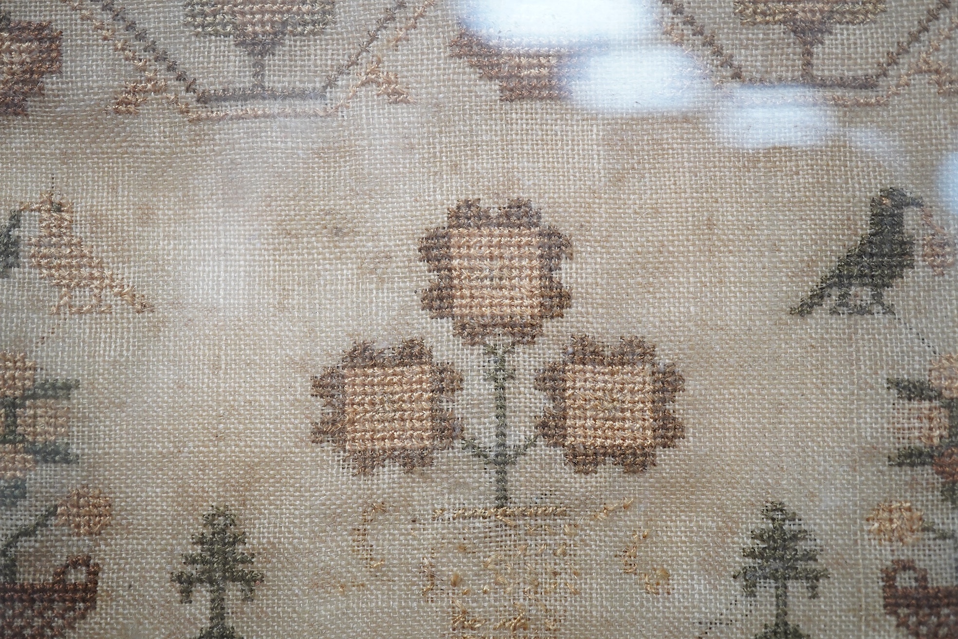 A spot motif and verse sampler, by Sarah Stow dated 1833, worked in multi-coloured silks, with a vineous border, a row of alphabet letters with a wide panel of spot motifs of birds and flowers above an embroidered verse